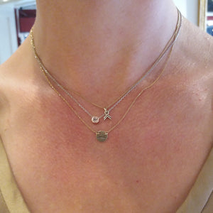 The small gold chevron pendant being worn, together with the small gearshift pendant and the gold 2cv silhouette necklace