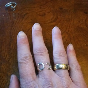 Sterling silver wrench ring wide, next to a gold tire ring